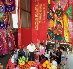  ??  ?? Caring for the environmen­t: Lim (in pink) speaking with Bandar Prai Jaya Phor Thor committee chairman Sin Sing Tiek and other committee members and devotees in front of the bronze statue of the deity at the temple.