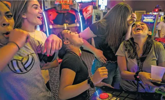  ??  ?? Laughter ensues when Jevani Hanspard (center) loses a game as the group celebrates making the team at Peter Piper Pizza in San Antonio.