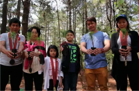  ?? Photo by Milo Brioso ?? FOR THE ENV’T. Lucky Summer Visitors Robert Flores, wife Lucina and granddaugh­ter Sophia Flores from Tondo, Manila with Kenn Evalobo, Adrian Evalobo and Jennifer Leon from Olongapo took time to plant a tree at Busol watershed Sunday morning to cap off...
