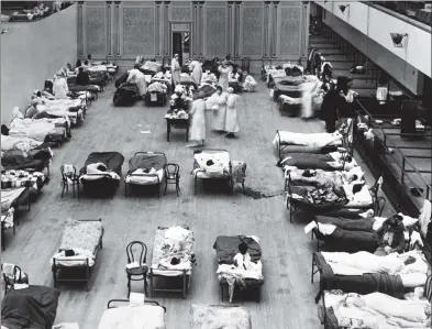  ?? Underwood Archives / Getty Images ?? The Oakland Municipal Auditorium is being used as a temporary hospital with volunteer nurses from the American Red Cross tending the sick there during the influenza pandemic of 1918 in Oakland, Calif.