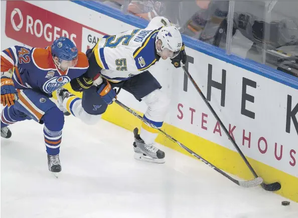  ?? GREG SOUTHAM ?? Edmonton defenceman Anton Slepyshev dogs puck carrier Colton Parayko of the Blues during first period action on Thursday night.