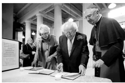  ?? AP PHOTOS ?? Ireland’s President Michael D Higgins and his wife Sabina sign a book of condolence­s before a memorial service for the victims of the New Zealand mosque attacks at St Mary’s Pro-Cathederal in Dublin, Ireland, yesterday.