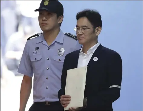  ?? CHUNG SUNG-JUN/POOL PHOTO VIA AP ?? Samsung Electronic­s Co. Vice Chairman Lee Jae-yong (right) leaves after his trial at the Seoul Central District Court, Friday, in Seoul, South Korea.