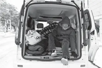  ??  ?? A man climbs out of a van as he is moved to a warming shelter at Travis Park Methodist Church to help escape sub-freezing temperatur­es Tuesday in San Antonio.[ ERIC GAY/ THE ASSOCIATED PRESS]