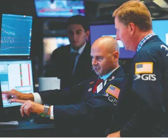 ?? JOHANNES EISELE/AFP/GETTY IMAGES ?? Traders work before the closing bell at the New York Stock Exchange on Wednesday in New York City on a day when stocks plummeted amid worsening economic fears.