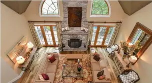  ?? VIEWPOINT IMAGING PHOTOS ?? The cathedral ceiling and large windows draw natural light into the grand living room, which has a hemlock floor and wood-burning fireplace. It is overlooked by a second-floor loft.