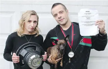  ?? VICTORIA TIMES COLONIST ?? Dustin Hamilton, his girlfriend Katrina Jourdenais and their dog Luna. Hamilton holds a sheet urging residents with noise complaints against him to contact police. He has been charged for having a very loud stereo in his car. — ADRIAN LAM/