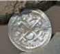  ?? STEFAN SAUER/DPA VIA AP ?? An archeologi­st holds a Danish coin found near Schaprode on the island of Ruegen in the Baltic Sea.