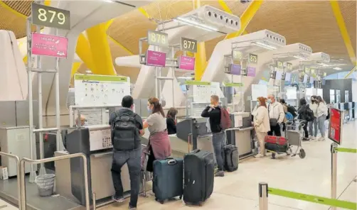  ?? EFE ?? Varios pasajeros facturan su equipaje en los mostradore­s de Iberia del aeropuerto Adolfo Suárez Madrid-Barajas.