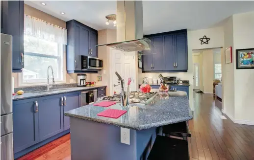  ?? PHOTOS: CHRIS MIKULA/OTTAWA CITIZEN ?? Stephen Sharp and Kelli Davy-Sharp’s kitchen features deep purple cabinetry and black granite countertop­s. ‘The kitchen was a primary focus in our design,’ Kelli says.