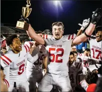  ?? JAMES BEAVER/FOR MEDIANEWS GROUP ?? Souderton’s Aongas Evanchick (52) celebrates his turn with the district championsh­ip trophy Friday night after defeating Pennridge for the title.