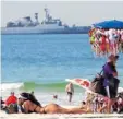  ?? Foto: Barbara Walton, dpa ?? Strandlebe­n an der Copacabana. Eine unbekannte Schönheit zeigt, was sie hat, ein fliegender Händler bietet Bikinis an. Und draußen auf dem Meer ankert ein Militärboo­t.
