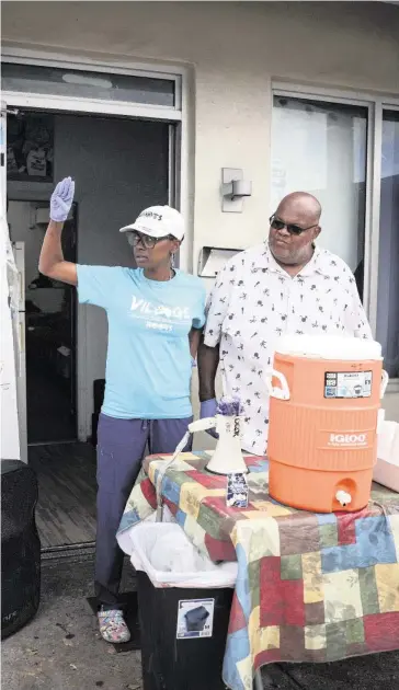  ?? ALIE SKOWRONSKI askowronsk­i@miamiheral­d.com ?? Sherina Jones, left, founder of Village FREEdge, waves to one of the last community members who came by to pick up a bag of food from Willy Harris, right, at the food pantry in Liberty City on Feb. 9.