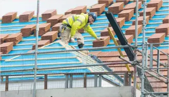  ?? (Neil Hall/Reuters) ?? A BUILDER works on the roof of a new residentia­l property developmen­t in north London. Successive government­s have promised to tackle a housing shortage that has seen house prices spiral in London and other major cities out of the reach of many buyers.