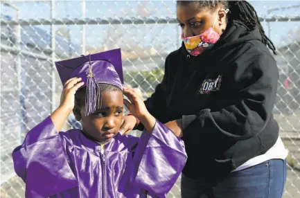  ?? Yalonda M. James / The Chronicle ?? Ashley Graham with son Christian Williams at Madison Park Academy Primary in Oakland. The school is set to reopen.