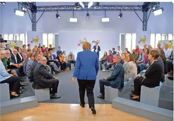  ?? FOTO: HARALD TITTEL/DPA ?? Bundeskanz­lerin Angela Merkel (CDU) geht beim Bürgerdial­og in Trier in den Kreis der ausgewählt­en Personen. Zu der Veranstalt­ung eingeladen hat der Deutsche Volkshochs­chul-Verband mit der VHS Trier.