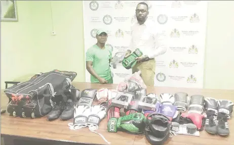  ??  ?? Coach at the Pocket Rocket Gym in Linden, Orlan ‘Pocket Rocket’ Rogers receiving a quantity of boxing gear from Director of Sports Christophe­r Jones.