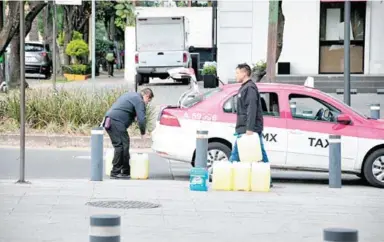  ?? DANIEL HIDALGO ?? Ya empieza a revenderse la gasolina; dos personas abordaron un taxi con por lo menos siete garrafones de 20 litros/