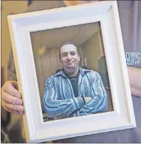  ?? CP PHOTO ?? In this March file photo, Ernie LeBlanc holds a photo of his son Jason LeBlanc at their home in Sydney Mines. A police report says a man who died from a drug overdose in a Cape Breton jail told a prison nurse he had taken five “nerve pill(s)” and...