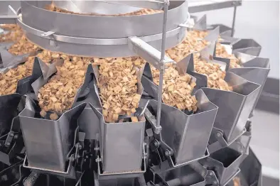  ?? ROBERTO E. ROSALES/JOURNAL ?? A machine at the General Mills factory weighs portions of cereal before the product travels to a packaging area.