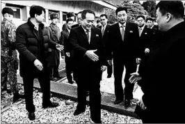  ?? KOREA POOL ?? The head of North Korea’s delegation, Ri Son Kwon, center, is greeted by South Korean officials Tuesday after he crosses the concrete curb that divides the two countries.