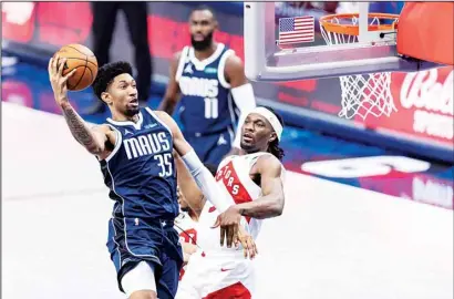  ?? ?? Dallas Mavericks forward Christian Wood (35) goes in for a layup as Toronto Raptors forward Precious Achiuwa (5) defends during the second half of an NBA basketball game in Dallas. (AP)