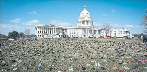  ?? ERIN SCHAFF/THE NEW YORK TIMES ?? About 7,000 shoes were displayed on the lawn next to the U.S. Capitol on Tuesday as part of a symbolic memorial to child victims of gun violence.