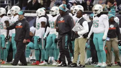  ?? File photo ?? The Miami Dolphins fired coach Brian Flores (holding playcard) after three seasons. Flores, who was previously the Patriots defensive coordinato­r, beat the Pats twice this season and went 9-8.