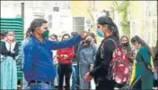  ?? DEEPAK SANSTA / HT ?? ■
A staff member checking the body temperatur­e of a student at RKMV College, Shimla, on Monday.