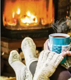  ?? Foto: volff, stock.adobe.com ?? Eine Tasse Tee, Kuschelsoc­ken und ein wärmendes Kaminfeuer – das ist der Inbegriff von winterlich­er Gemütlichk­eit. Doch Heizen mit Holz will gelernt sein, damit nicht das Klima oder die Gesundheit leidet.