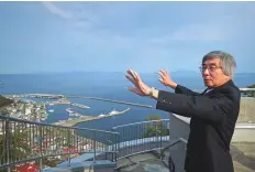  ??  ?? Kimio Waki, a former resident of the island of Kunashiri, gesturing over a view of the island.