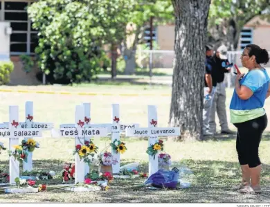  ?? TANNEN MAURY / EFE ?? Una mujer observa las cruces con los nombres de las víctimas del tiroteo en Uvalde.