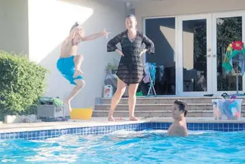  ??  ?? Deanna Peysekhman, watches her son, Nate, left, and nephewDeni­sTrifonov at herparents’pool in Hollywood onThursday­The Peysekhman­s, of Freehold, NewJersey are staying in South Florida at least through mid-January.