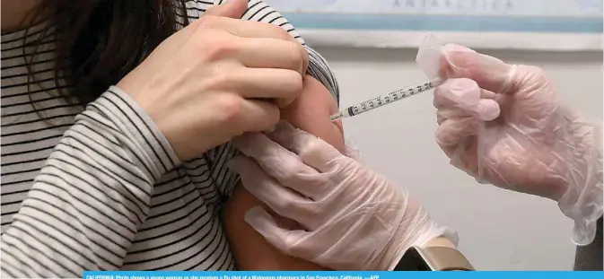  ??  ?? CALIFORNIA: Photo shows a young woman as she receives a flu shot at a Walgreens pharmacy in San Francisco, California. —AFP