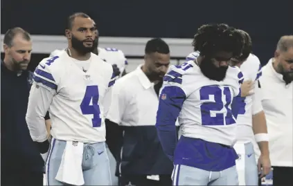  ?? AP PHOTO/MICHAEL AINSWORTH ?? Dallas Cowboys’ Dak Prescott (4) and Ezekiel Elliott (21) stand during the playing of the national anthem before the half of a preseason NFL football game against the Jacksonvil­le Jaguars in Arlington, Texas, on Aug. 29.