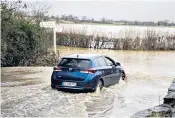  ?? ?? A car battles through flooding in Wiltshire as 41 flood warnings are issued in the UK