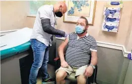  ?? CARLINE JEAN/SOUTH FLORIDA SUN SENTINEL ?? Dr. Zachary Henry, of the Aids Healthcare Foundation North Point HCC in Fort Lauderdale, administer­s the Moderna vaccine to Robert Vadeboncoe­ur, of Oakland Park, on March 10.