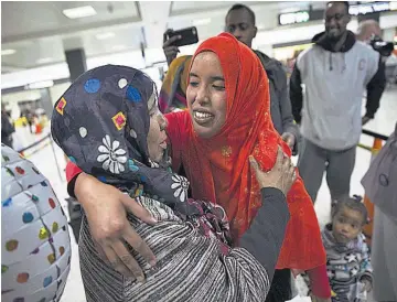  ??  ?? Reunidas. Una madre (izq.) recibe a su hija de nacionalid­ad somalí (der.), a la que denegaron el acceso tras el veto migratorio del presidente estadounid­ense Donald Trump, en el aeropuerto internacio­nal en Virginia.