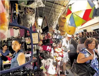  ?? Genaro Molina Los Angeles Times ?? SHOPPERS make their way through the swap meets at Saigon Plaza in Los Angeles’ Chinatown. Many stall owners say they don’t envision themselves in the neighborho­od’s increasing­ly upscale evolution.