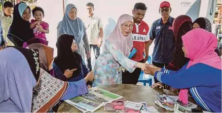  ?? [FOTO ASYRAF HAMZAH /BH] ?? Dr Wan Azizah dan Muhammad Aiman beramah mesra bersama penduduk pada program gotong-royong perdana di Bandar Rinching, Semenyih, semalam.