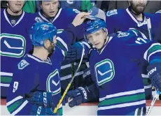  ??  ?? Vancouver Canucks’ Brandon Prust, left, places a hat that was thrown onto the ice on the head of Radim Vrbata, after Vrbata scored his third goal against the Buffalo Sabres Monday night at Rogers Arena.