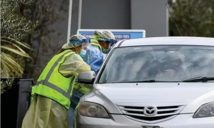  ?? Photograph: Bianca de Marchi/AAP ?? New South Wales Health workers administer coronaviru­s tests to people in their cars at the Crossroads Hotel in south-west Sydney.