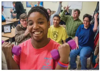  ?? WILLIAM HARVEY/THREE RIVERS EDITION ?? Jessica Sears works out with small weights as her classmates at The Sunshine School cheer her on. Sears has been named to Team Arkansas for the 2018 Special Olympics USA games in July. She will compete in powerlifti­ng.