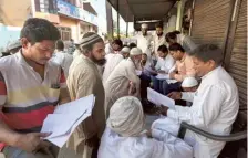  ?? ?? People check for their names in the voters’ list as they arrive to vote in Nahal village near Meerut on Friday.