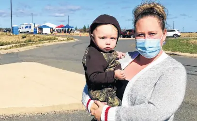  ?? NICOLE SULLIVAN • CAPE BRETON POST ?? Georgia White holds her son Easton Lewis near the mobile primary health-care clinic that Nova Scotia Health has opened in Membertou, off Highway 125, on Friday.