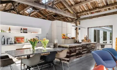  ?? ANDRE MCKENZIE PHOTOS SILVERHOUS­EHD.COM ?? The open kitchen and dining area include an island clad in reclaimed planks that were kiln-dried and sealed with epoxy resin.