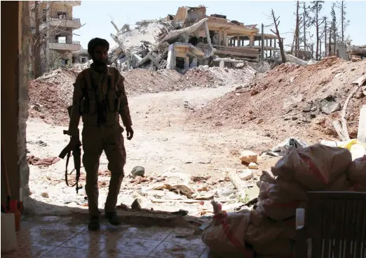  ??  ?? A Free Syrian Army fighter stands in the Manshiya neighborho­od, a rebel-held part of the southern city of Daraa. (Reuters)