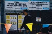  ??  ?? Gustavo Cano, 21, who has already been vaccinated, reads a banner with the “Safe Steps to Safe Schools” instructio­ns before getting a free test at a COVID-19 testing and vaccinatio­n site set up by the Los Angeles Unified School District in East Los Angeles on Thursday.