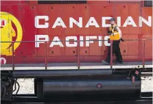  ?? JEFF McINTOSH, CANADIAN PRESS ?? A Canadian Pacific Railway employee walks along the side of a locomotive in a marshallin­g yard in Calgary.