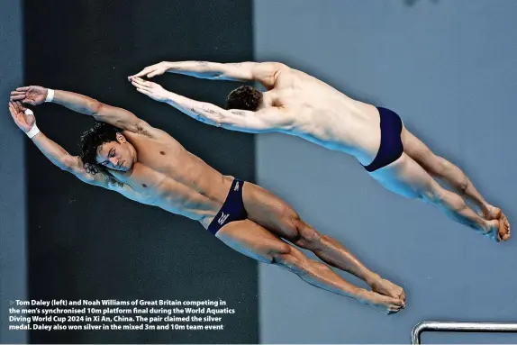  ?? Wang He/Getty Images ?? > Tom Daley (left) and Noah Williams of Great Britain competing in the men’s synchronis­ed 10m platform final during the World Aquatics Diving World Cup 2024 in Xi An, China. The pair claimed the silver medal. Daley also won silver in the mixed 3m and 10m team event